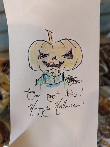 little Halloween doodle in crayon and pen. A pumpkin headed figure tells the viewer "you got this! Happy Halloween!". They wear a blue apron and green shirt