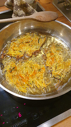 raw hash-browns in sizzling pan