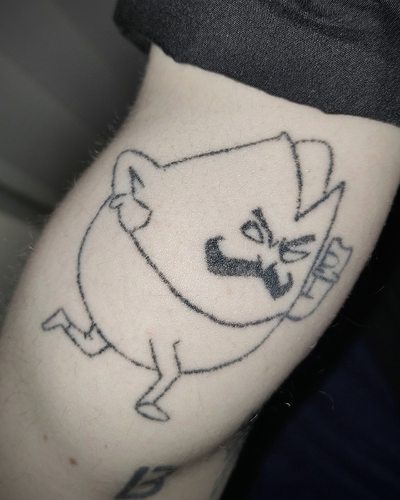 photo of a fairly sketchy stick and poke tattoo of Mustachio from the game Left 4 Dead 2. It's on a very pale arm.