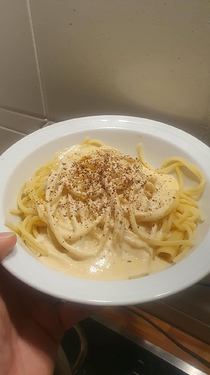 Plate of Spaghetti with cheese sauce and pepper on top