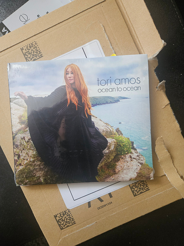 A CD copy of the Tori Amos album Ocean to Ocean. The cover shows Tori standing on some cliffs in Cornwall looking windswept and interesting in a big black caped dress.