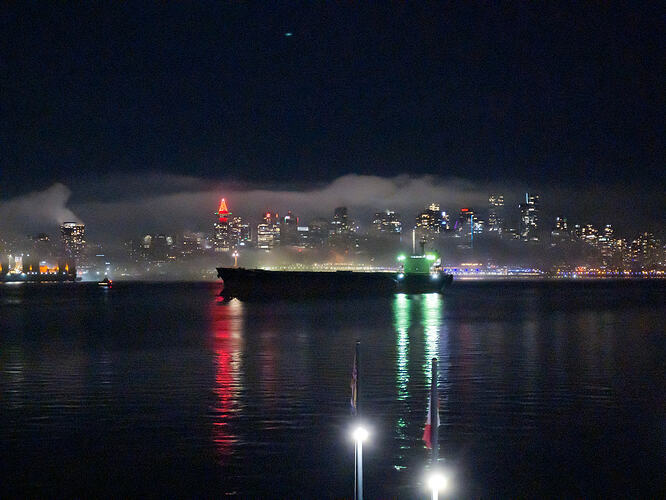 Downtown Vancouver skyline on New Years Eve, surrounded in mist, with a cargo ship in front