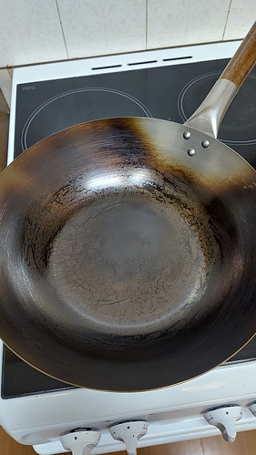 the same wok, this time seasoned and starting to blacken. There's some obvious streaks which may prove problematic as layers accumulate, but it's still working fine for now!