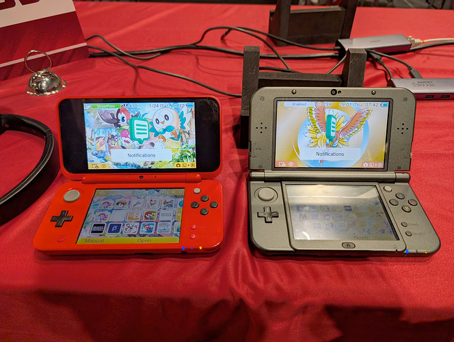 my 2DS XL and New 3DS XL's side by side on a red table
