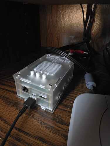 A photo of my MiSTer pi FPGA machine that's plugged into my JVC CRT Television. It's in a semi-transparent white case and sitting next to a Playstation One model PS1.