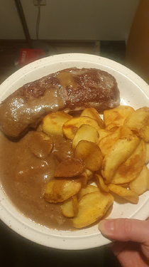 steak, beige sauce and potato chips in plate